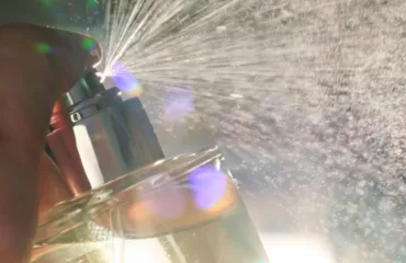 Yak chytaty opys not i stiykosti na sayti TIMSS instruktsiya dlya novykh kliyentiv Close-up of a hand holding a small torch, sparks spraying toward a glass of champagne in a dim setting.